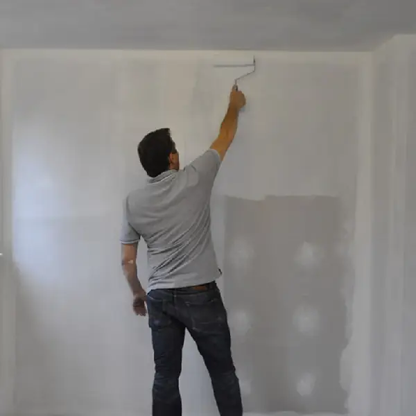 a man priming a wall